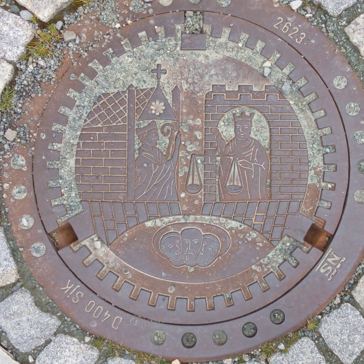 Centrální reliéf zobrazuje dvě postavy, jednu s biskupskou mitrou a berlou, druhou s korunou a vahou, symbolizující zřej in Trondheim, Norway — CoverSpot
