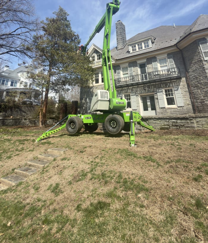 Blue Rock's compact spider lift working in a tight residential backyard — fits through narrow gates