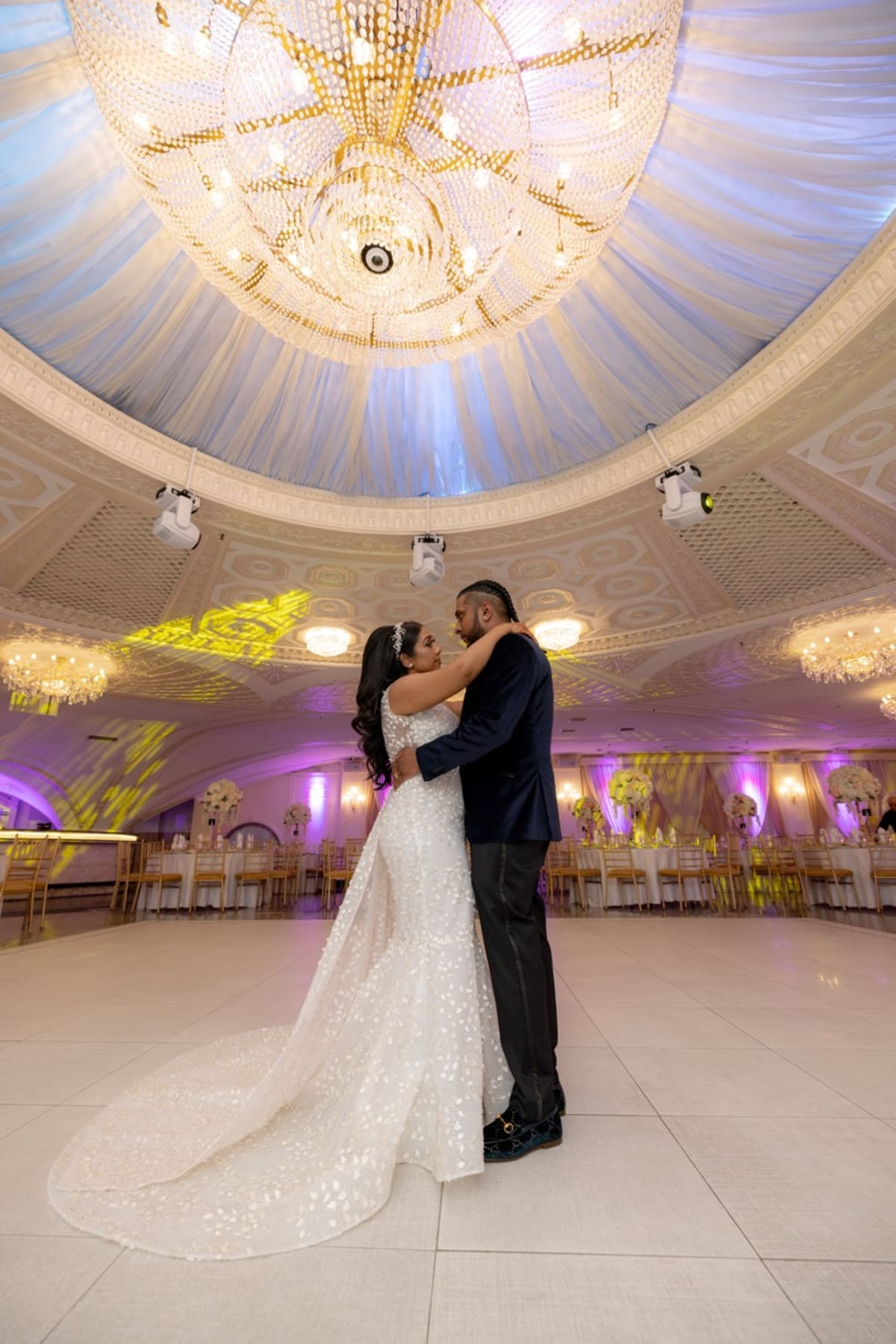 First dance beneath a grand chandelier in a luxury ballroom