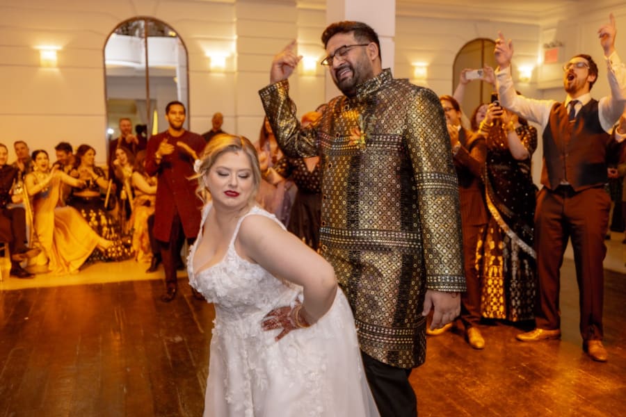 Bride and groom celebrating on the dance floor with guests