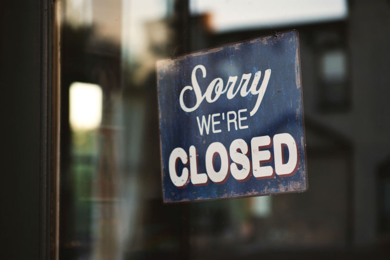 Vitrine de loja com o sinal dizendo "Sorry, we're closed"