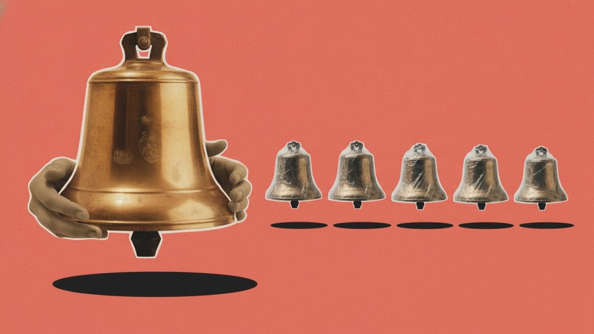 A large brass bell polished by decades of hands, beside five identical new bells still dull in their wrapping