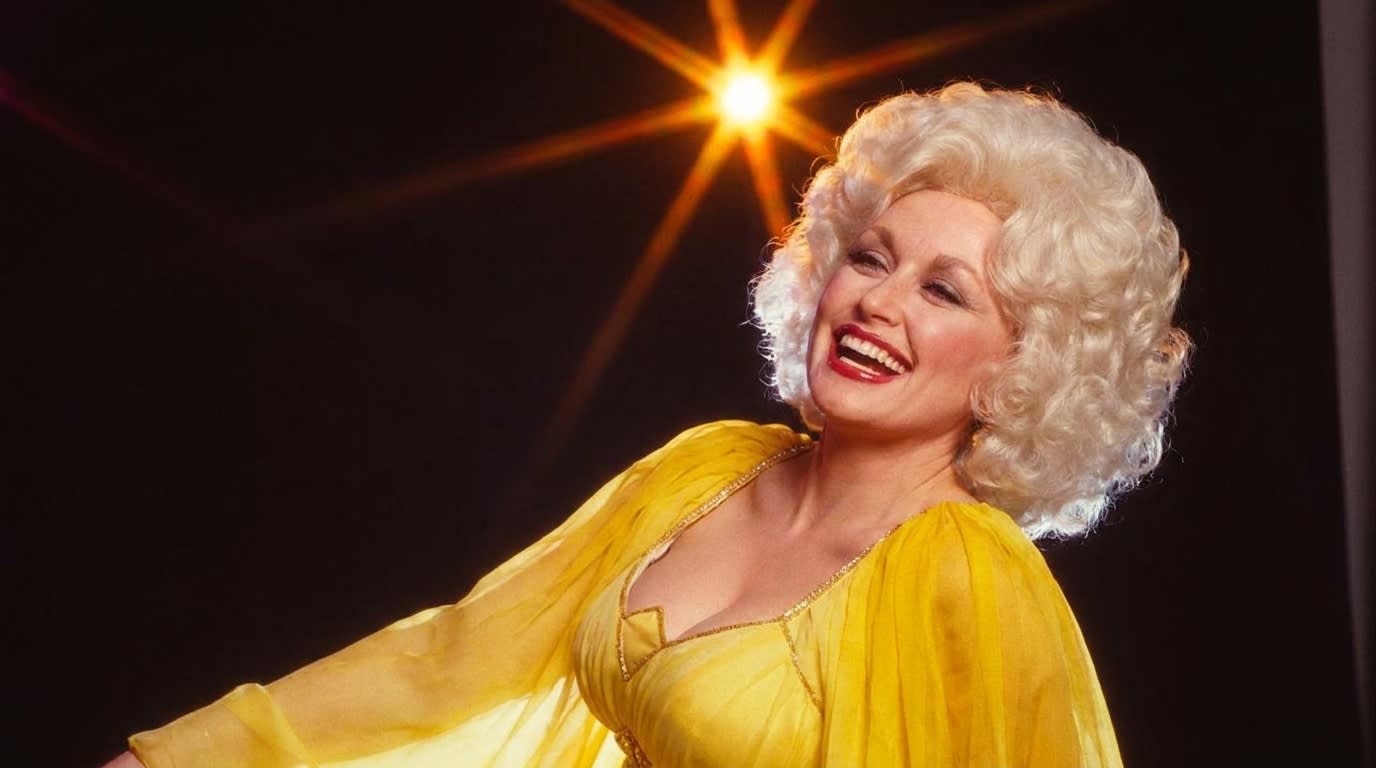 Dolly Parton laughing in a yellow chiffon dress, late 1970s