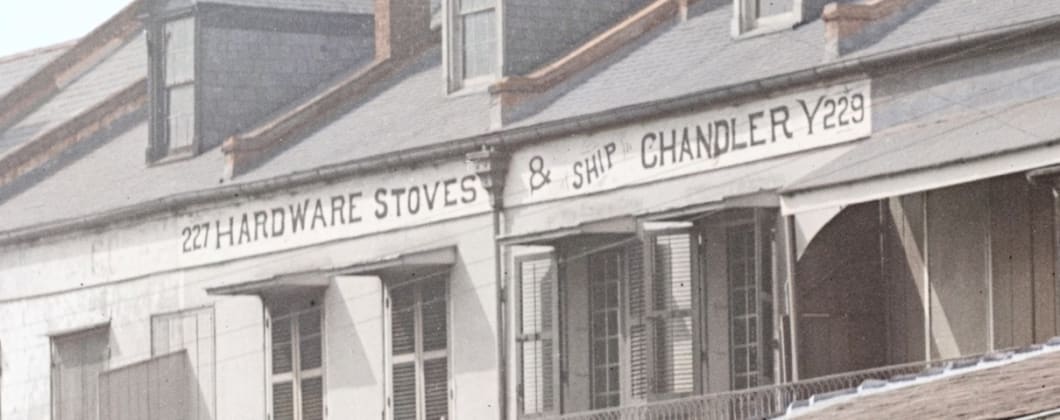 Detail from the plate: the painted shopfront band reading 227 Hardware Stoves and Ship Chandlery 229