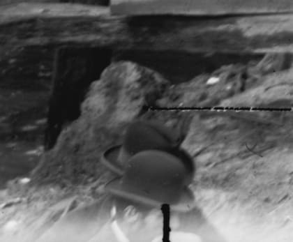 Detail from the plate: a man in a hat at the bottom edge of the frame, blurred by his own movement