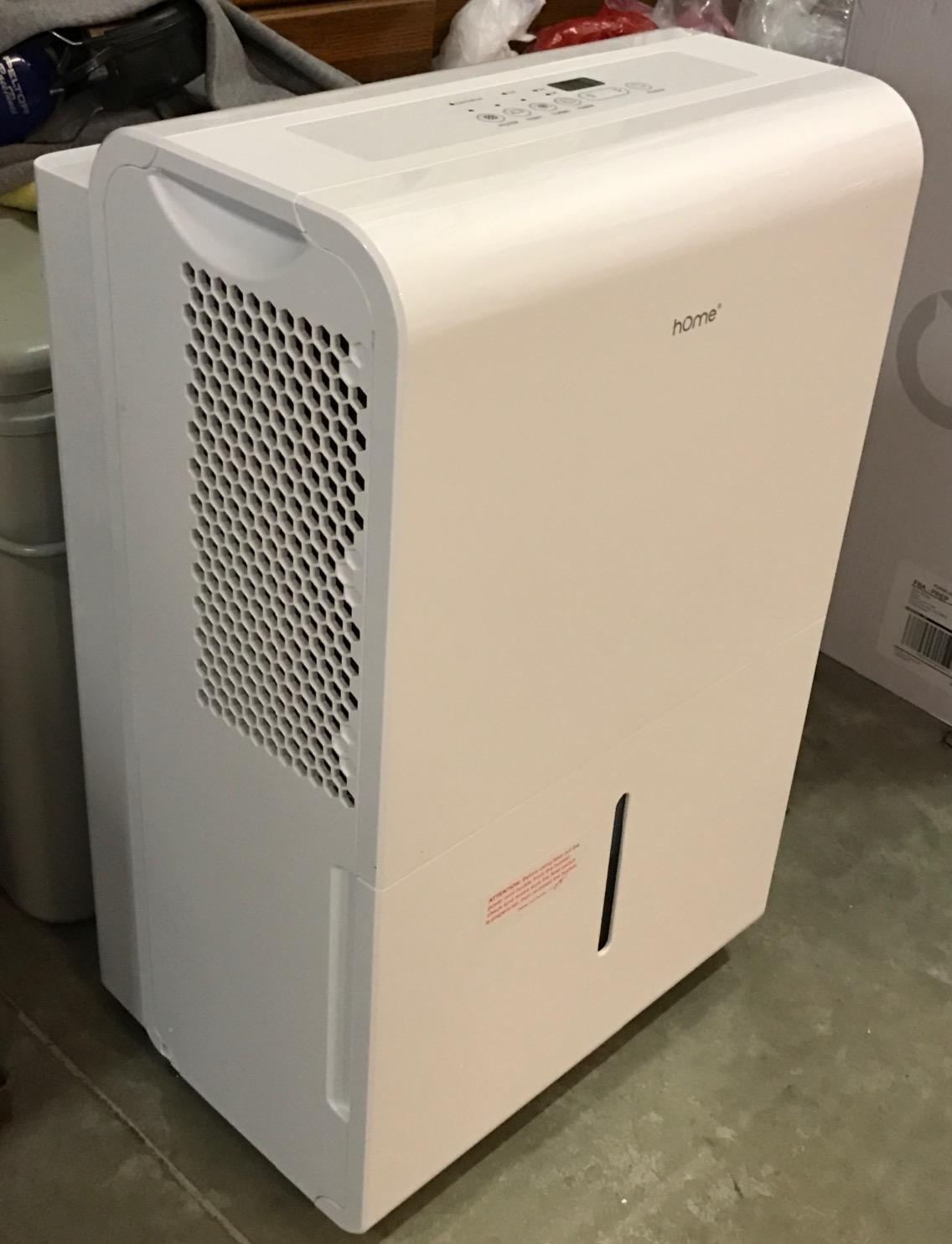 Side view of the white hOmeLabs dehumidifier showing the honeycomb air intake grille and front water tank level indicator window