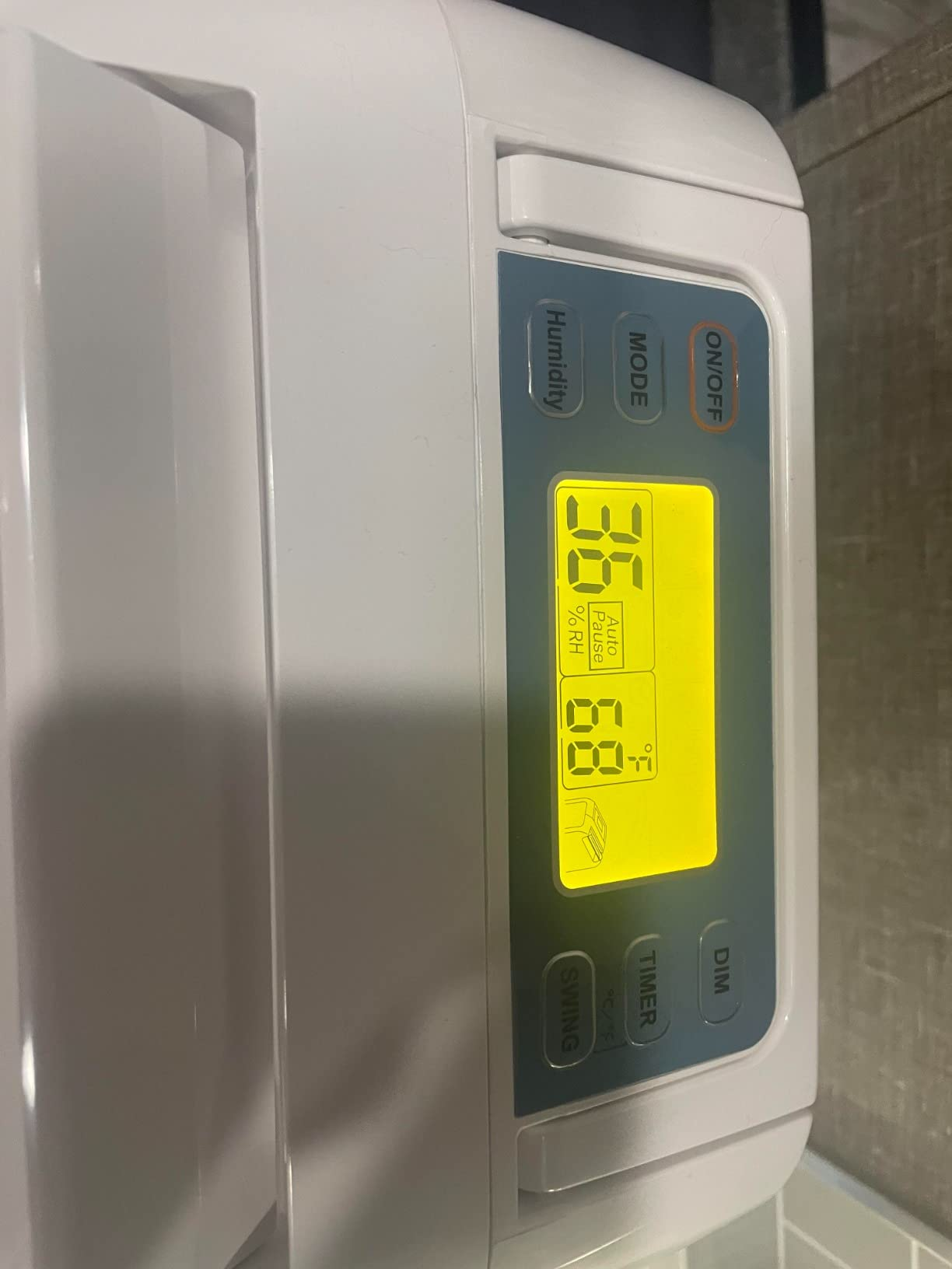 Bright yellow LCD control panel on the Ivation desiccant dehumidifier displaying 36% relative humidity and 68 degrees F