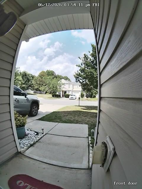 Daytime color live feed from the Reolink Video Doorbell WiFi showing the front walkway, driveway, and street