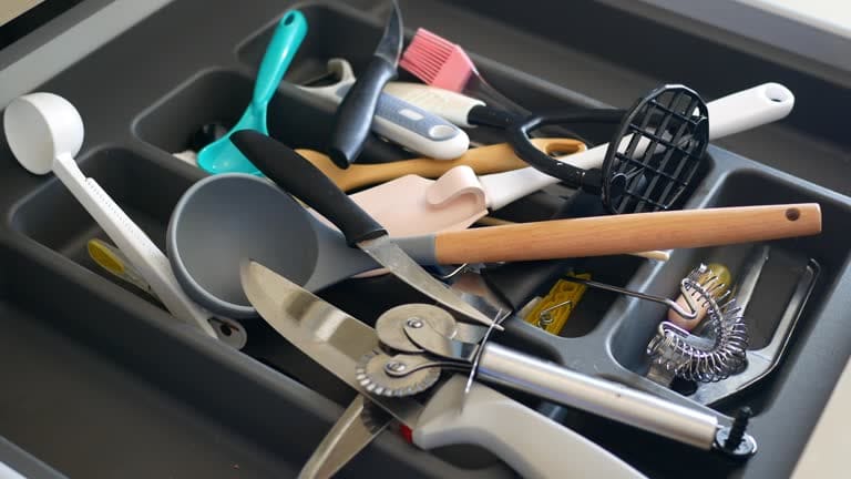 A collection of essential BIFL kitchen tools arranged on a wooden countertop