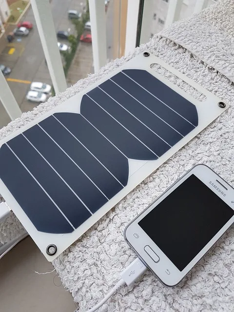 Solar charger powering up a smartphone in nature.