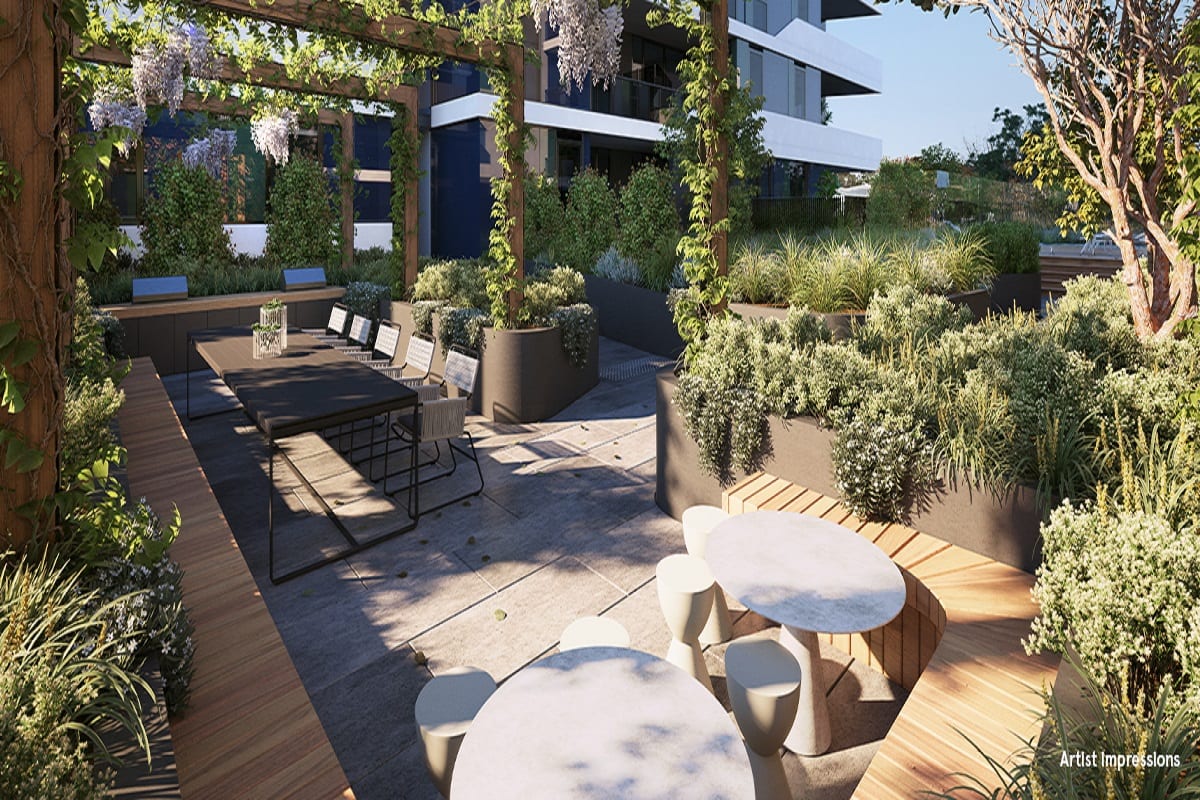 A lush garden and sundeck with outdoor lounge and dining spaces.