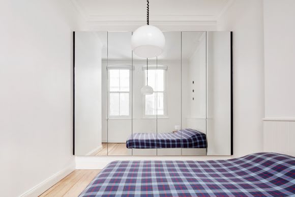 Flinders Lane apartment bedroom features mirrored cupboards to create the illusion of more space. Credit: Nicholas Gurney Is Australia ready for smaller footprint apartment living?