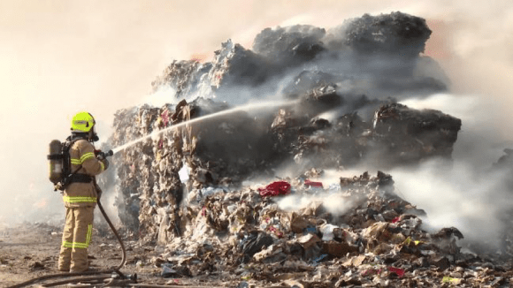 Firefighter hosing Coolaroo recycling fire – Image: news.com.au Turmoil and Triumph in Victoria’s Waste World