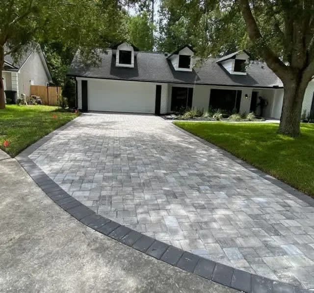 Paver Driveway: Interlocking pavers with a contrasting border and a curved driveway apron.