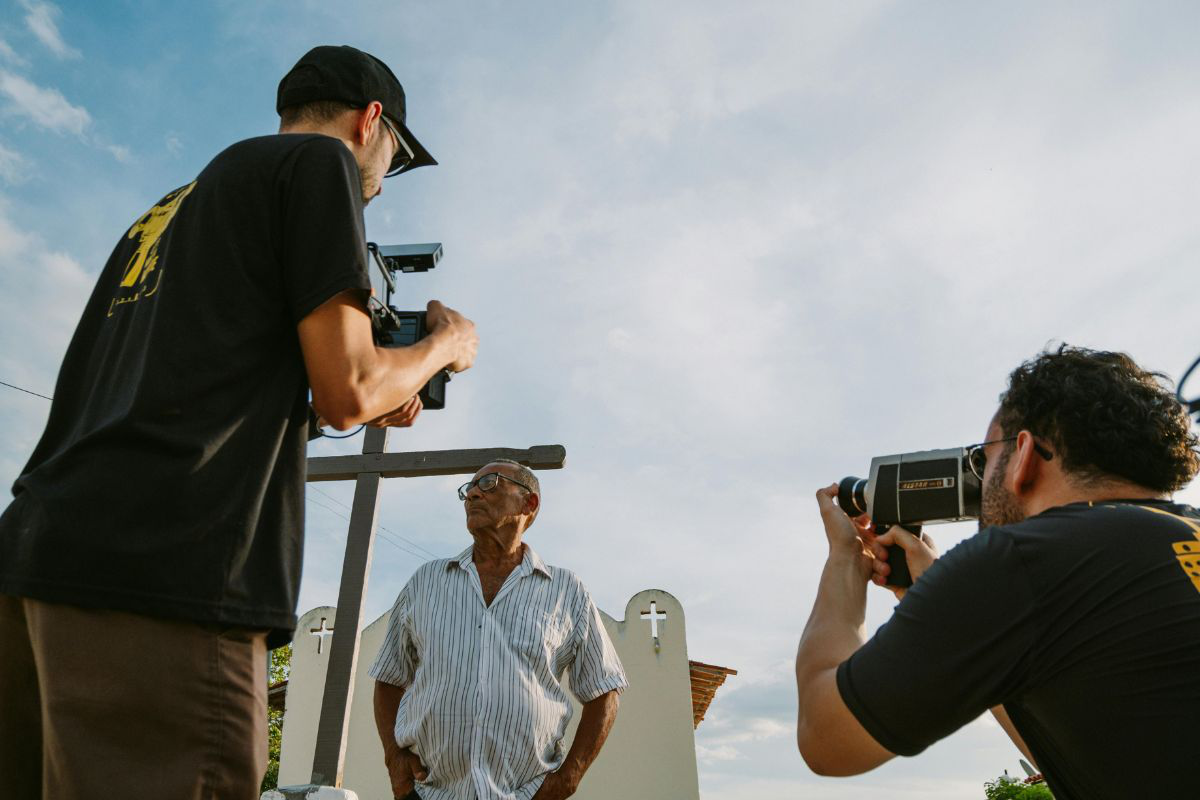 Deux hommes en train de filmer un troisième pour faire un portrait de lui.
