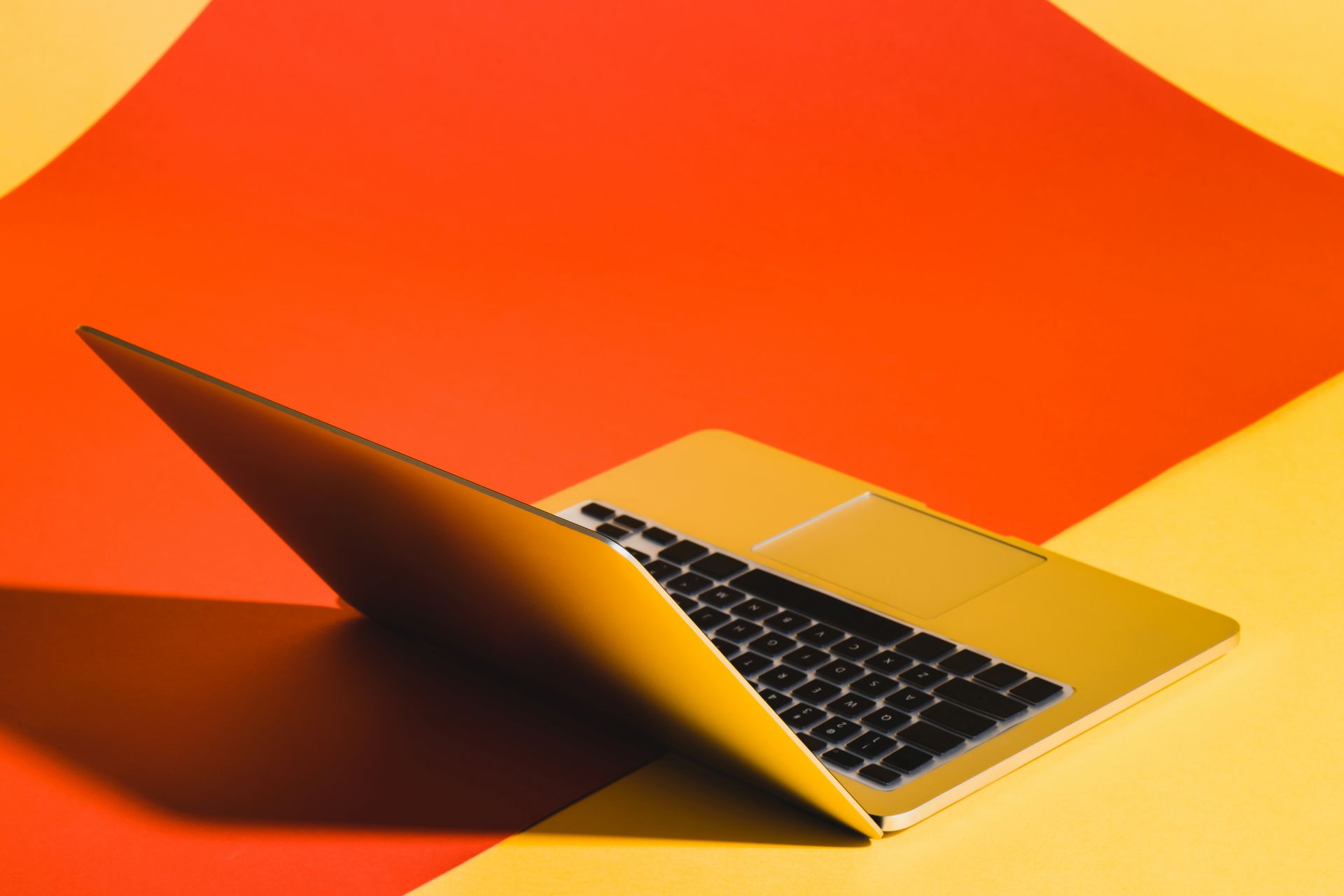 un ordinateur portable sur fond jaune et orange