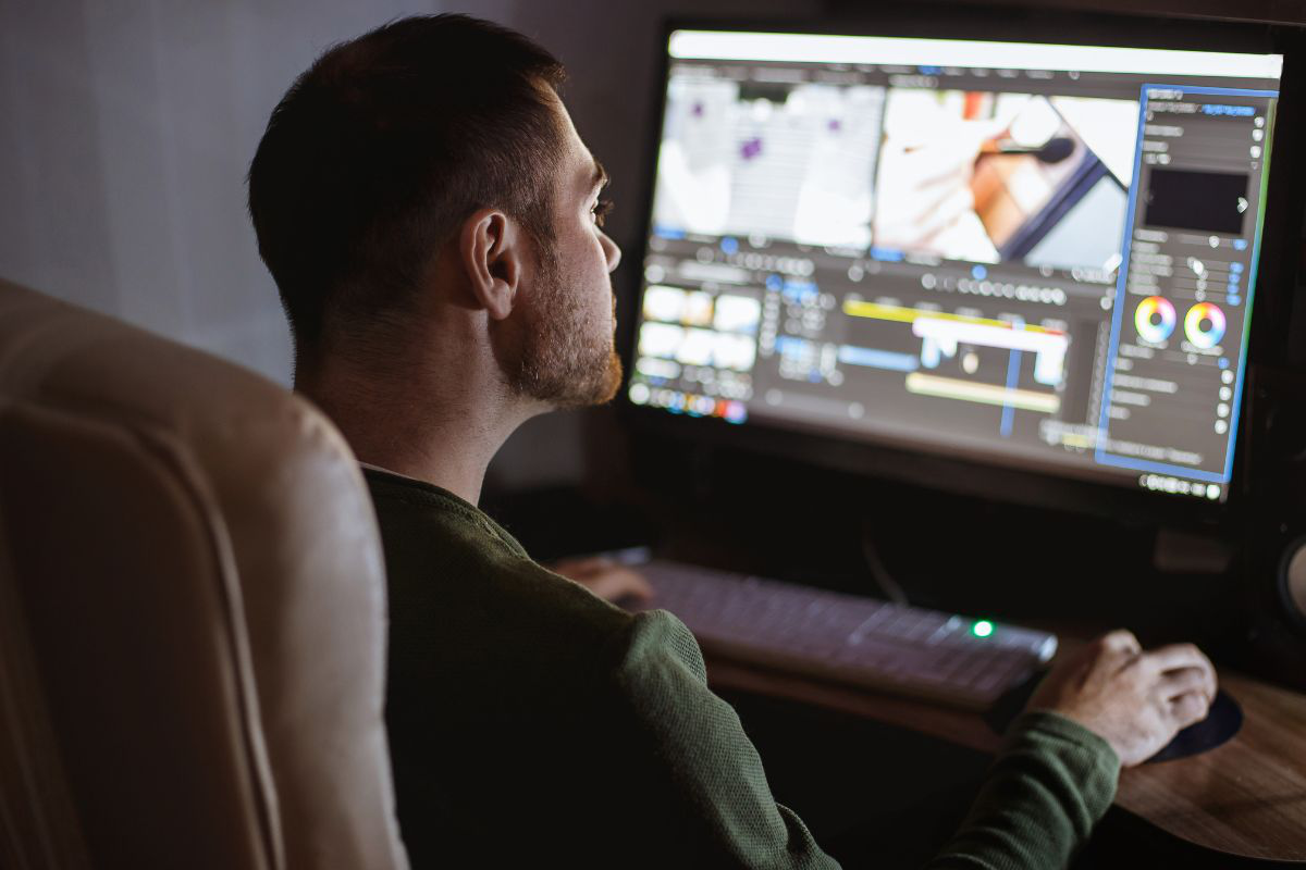 un homme faisant du montage vidéo sur un écran - creator academy