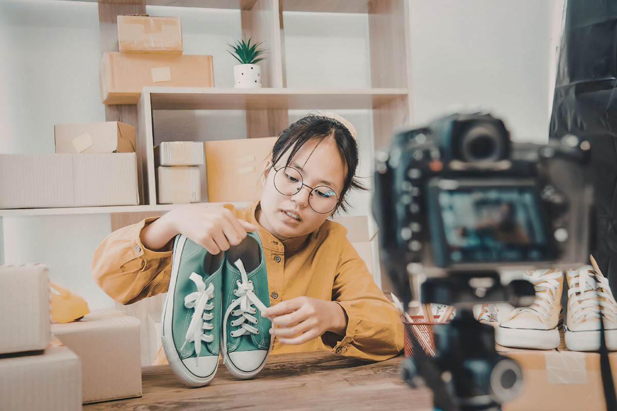 Une personne fait une vidéo pour présenter une nouvelle pair de chaussure - Creator academy