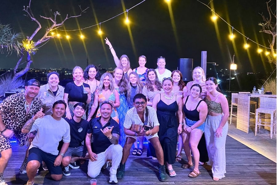 Travsessed travelers and their Bali hosts celebrating together at night