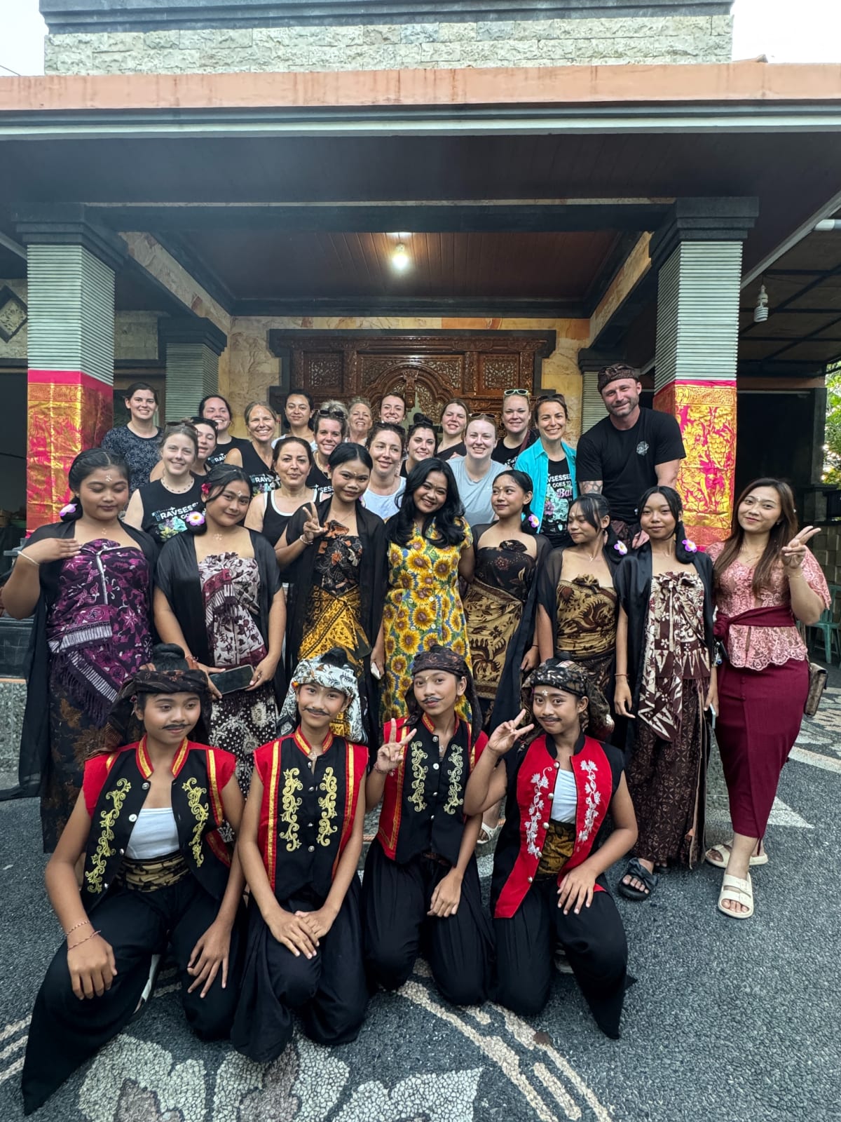 Travsessed travelers sharing a cultural experience with a Balinese performance group