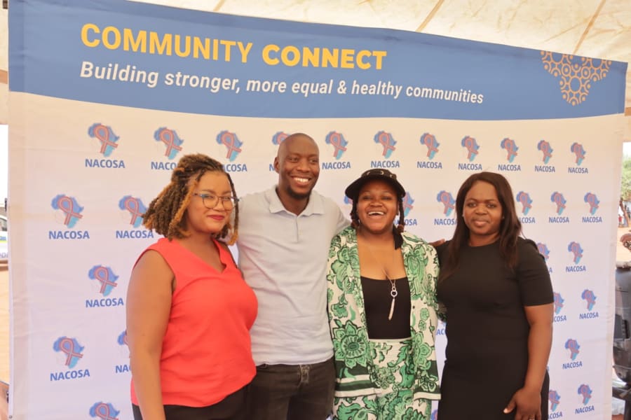 Four people standing in front of a Community Connect partnership backdrop.