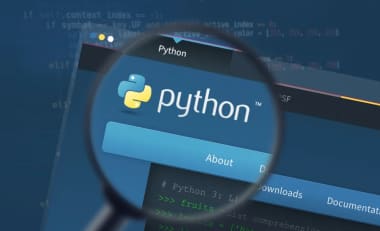 Interfaz de código Python en una laptop con el curso de Udemy de fondo