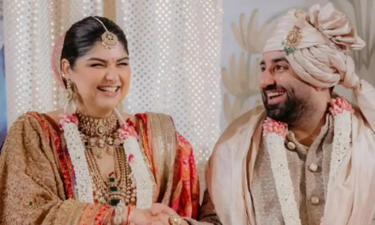 "Newlyweds Anshula Kapoor and her husband smile during their wedding celebrations in Mumbai, dressed in traditional attire with floral garlands and festive jewelry."