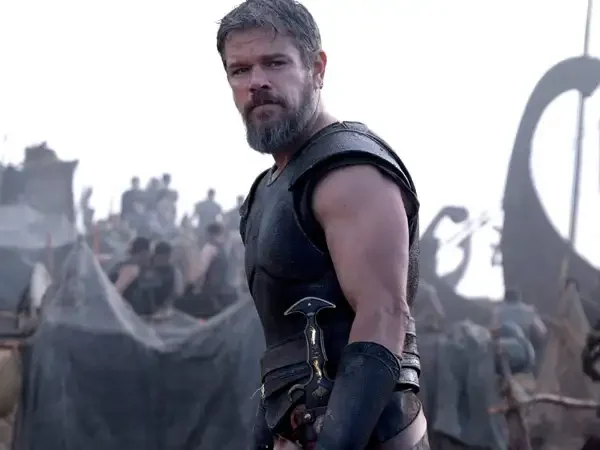 "Matt Damon as Odysseus in Christopher Nolan's The Odyssey, wearing ancient Greek warrior armor on a battlefield during the epic adventure film."
