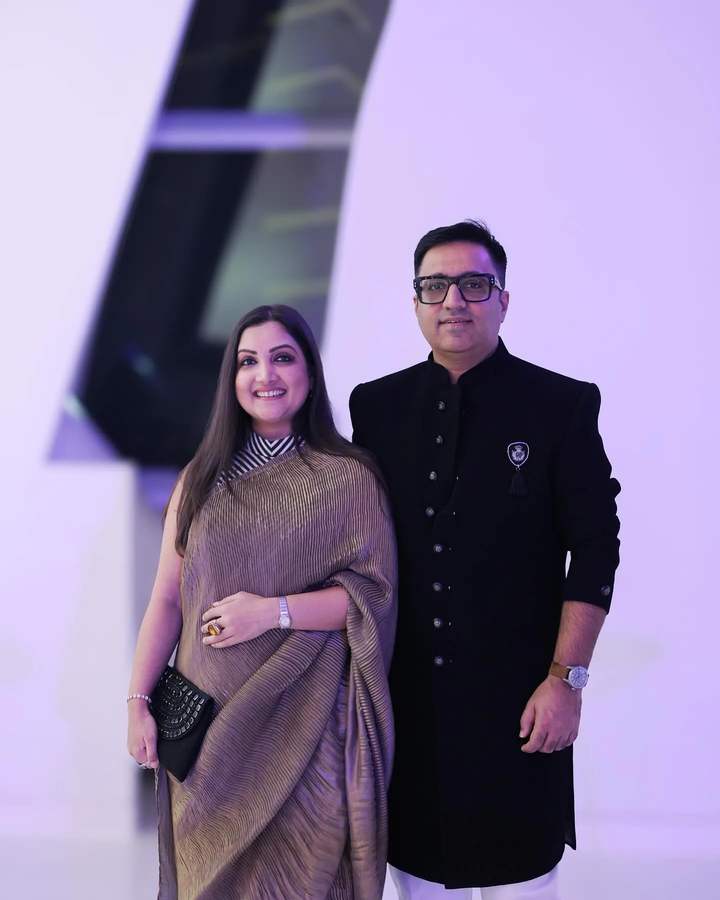 "Madhuri Jain Grover and her husband pose together at a formal event, dressed in elegant traditional attire, amid ongoing attention surrounding the Lock Upp 2 controversy."