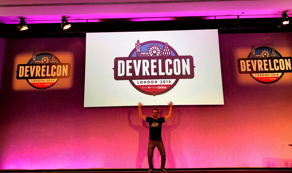 Josh Dzielak with hands up on stage at DevRelCon London