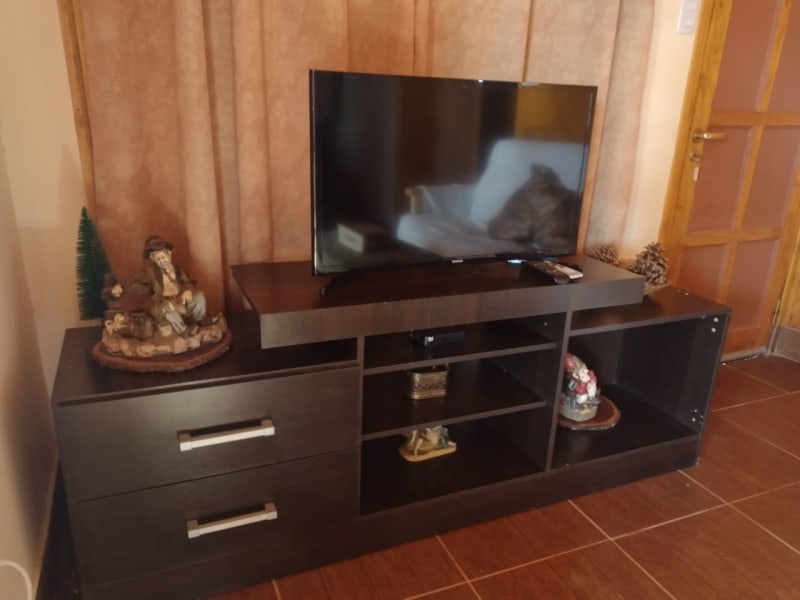 Televisor sobre mueble rack de madera con decoración rústica en la sala de estar