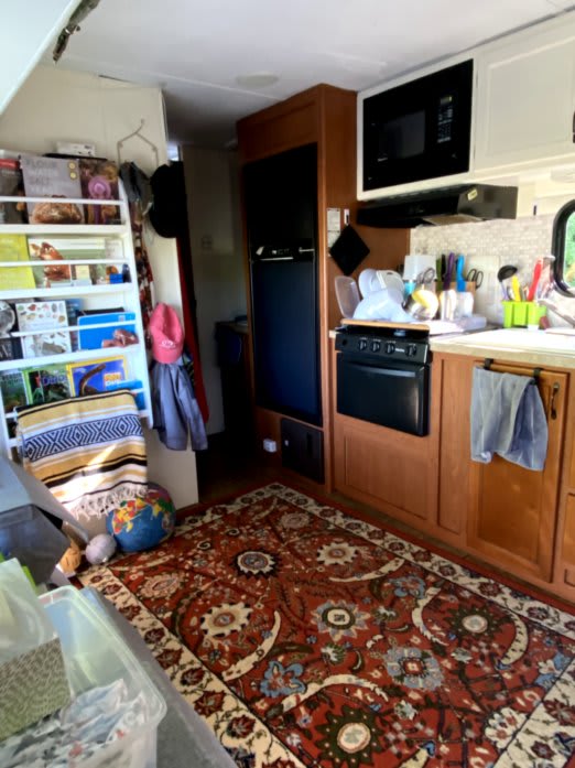 A look at our camper when it's clean. Features a rug, bookshelf, and other home-y touches.