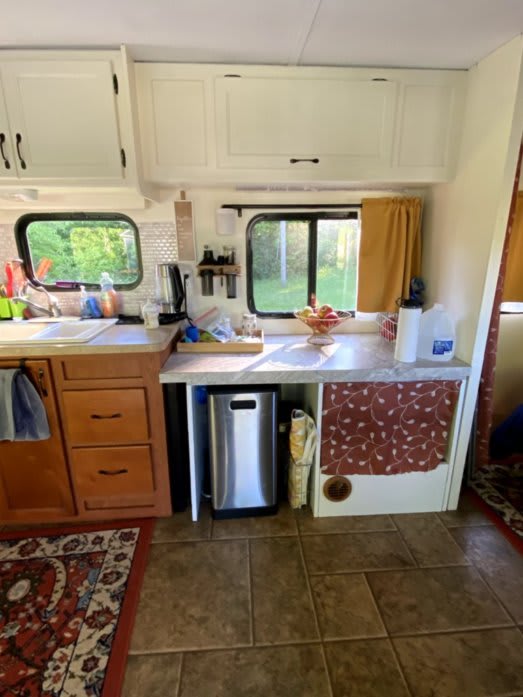 Indoor photo of our convertible desk setup. You can see the trash can tucked neatly underneath, and the countertop is neat and tidy.