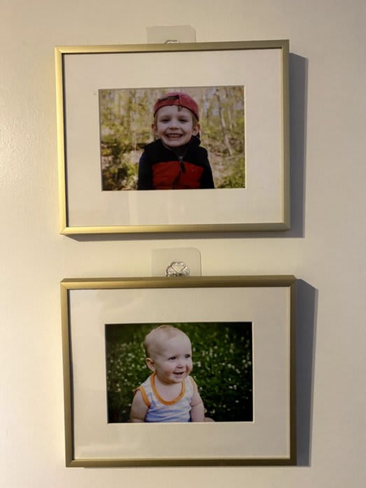 Two photo frames, hanging by adhesive hooks