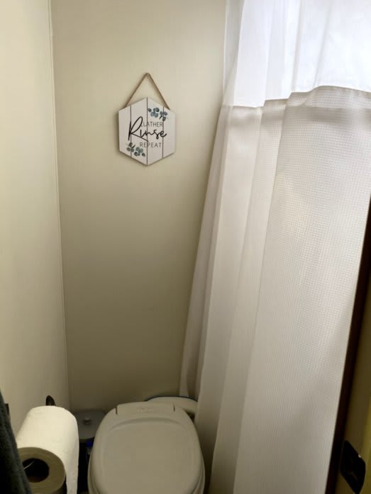 our bathroom. There is a small decorative hanging item above the toilet that reads &quot;Lather, Rinse, Repeat&quot;