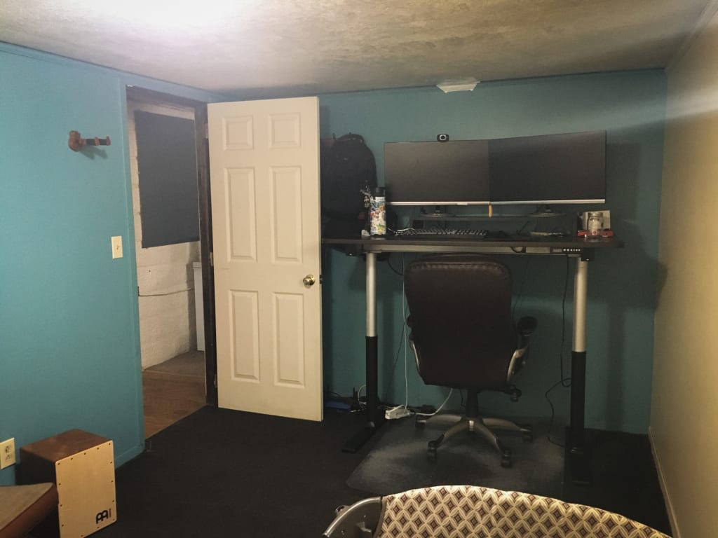 Alex's office when he lived in a house. Features a standing desk, two large monitors, and a quiet room.