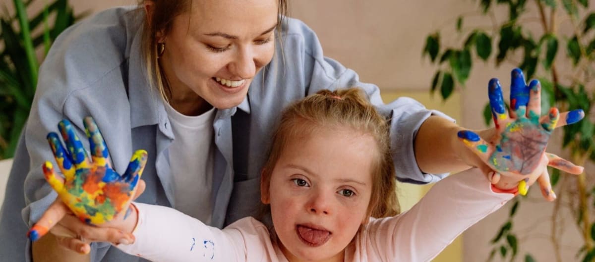 Parent and adult child with Down syndrome talking together at home