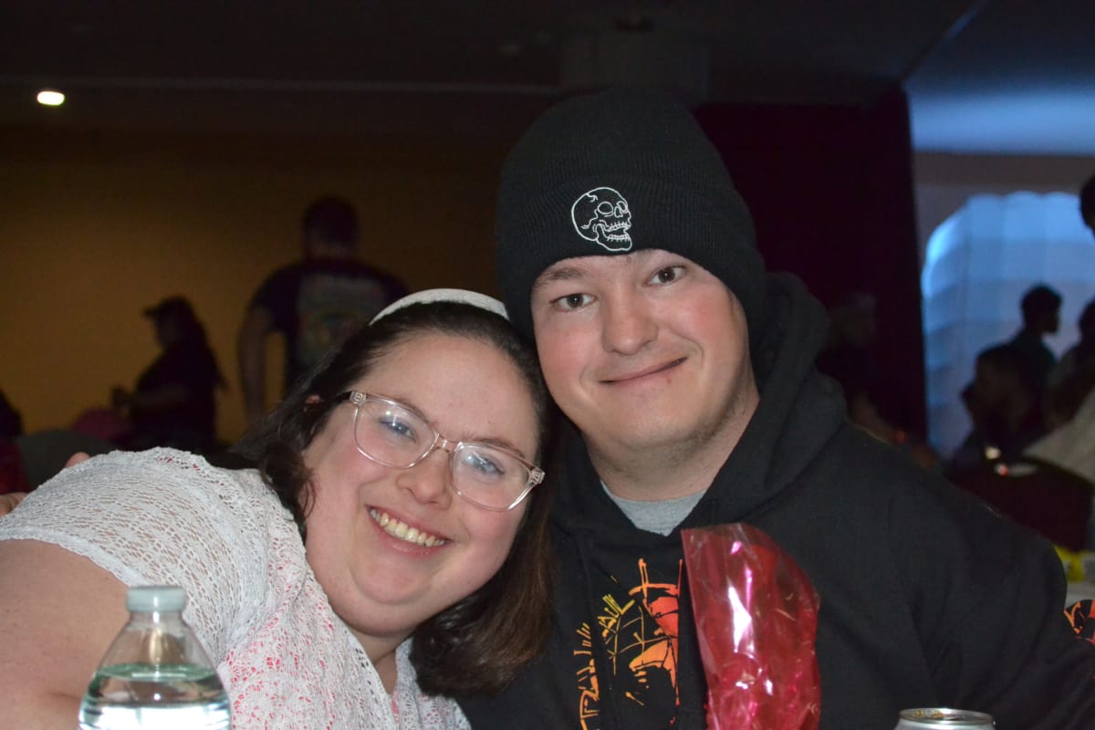 Two young adults smiling together at an Arc social event