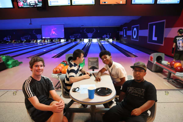 Teen guys enjoying a bowling night out organized by The Arc PPR