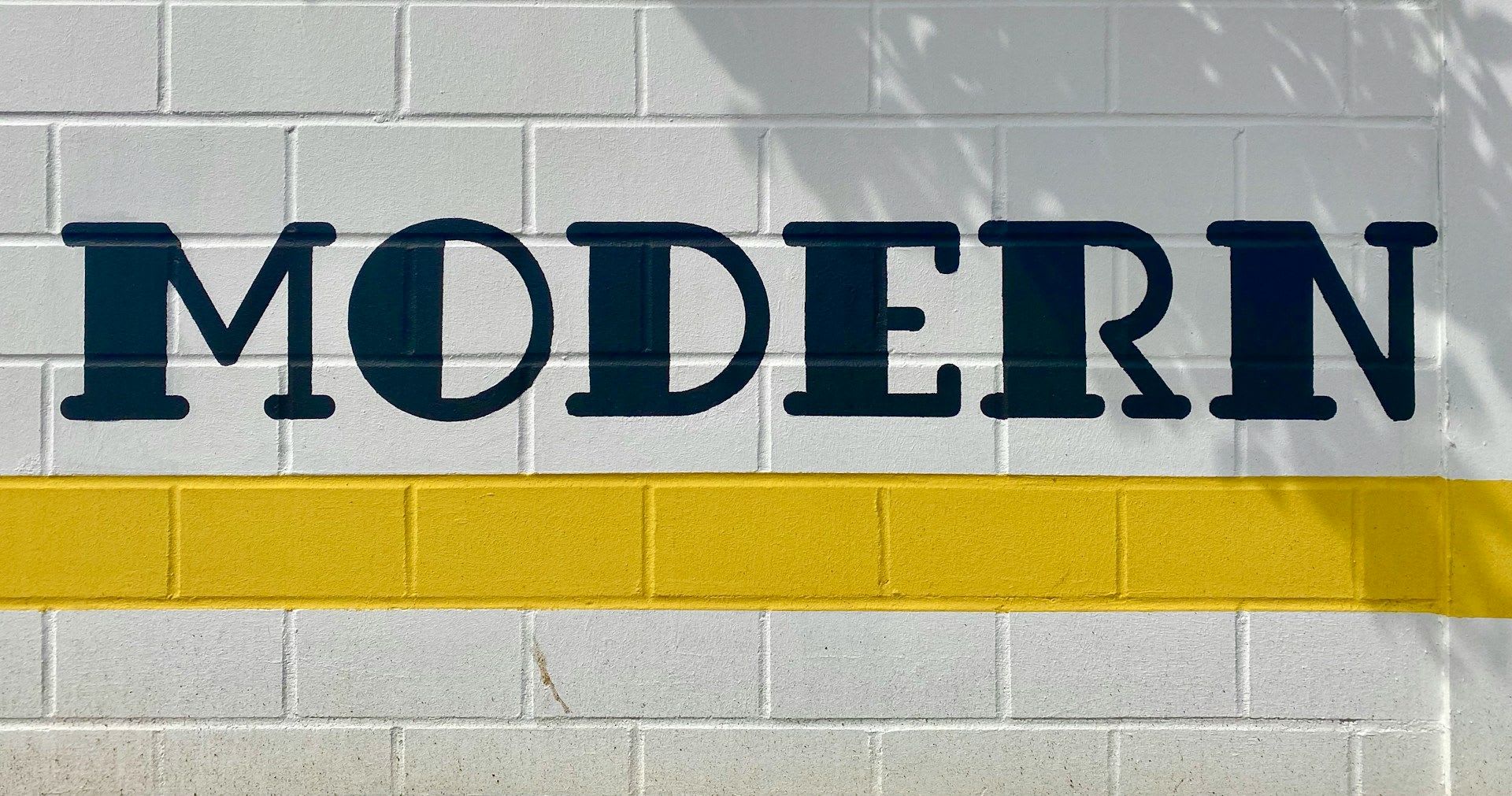 White brick wall displaying the word “Modern”.