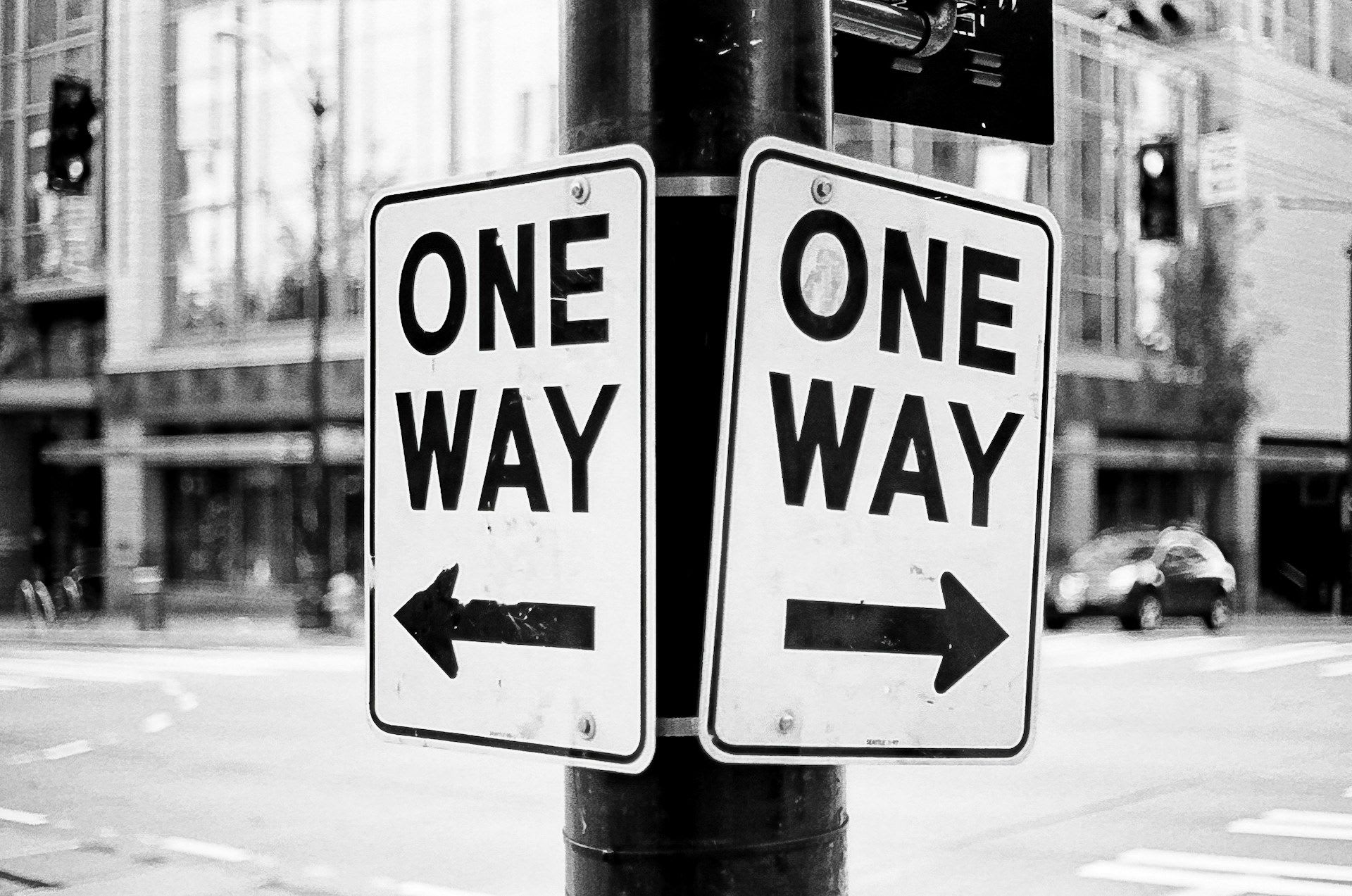 Two signs indicating the direction with the text "ONE WAY".