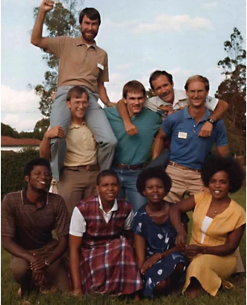 High School staff, 1980s. L-R Kneeling: Musyoka, Glenda, Irene, Sarah Standing: Tom Lawrence, Robin Tyner (on shoulders) Bruce Nygaard, John O'Hair, Bob Meredith