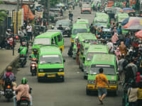 Jalanan ramai dengan kendaraan bermotor dan aktivitas lalu lintas yang padat di area perkotaan
