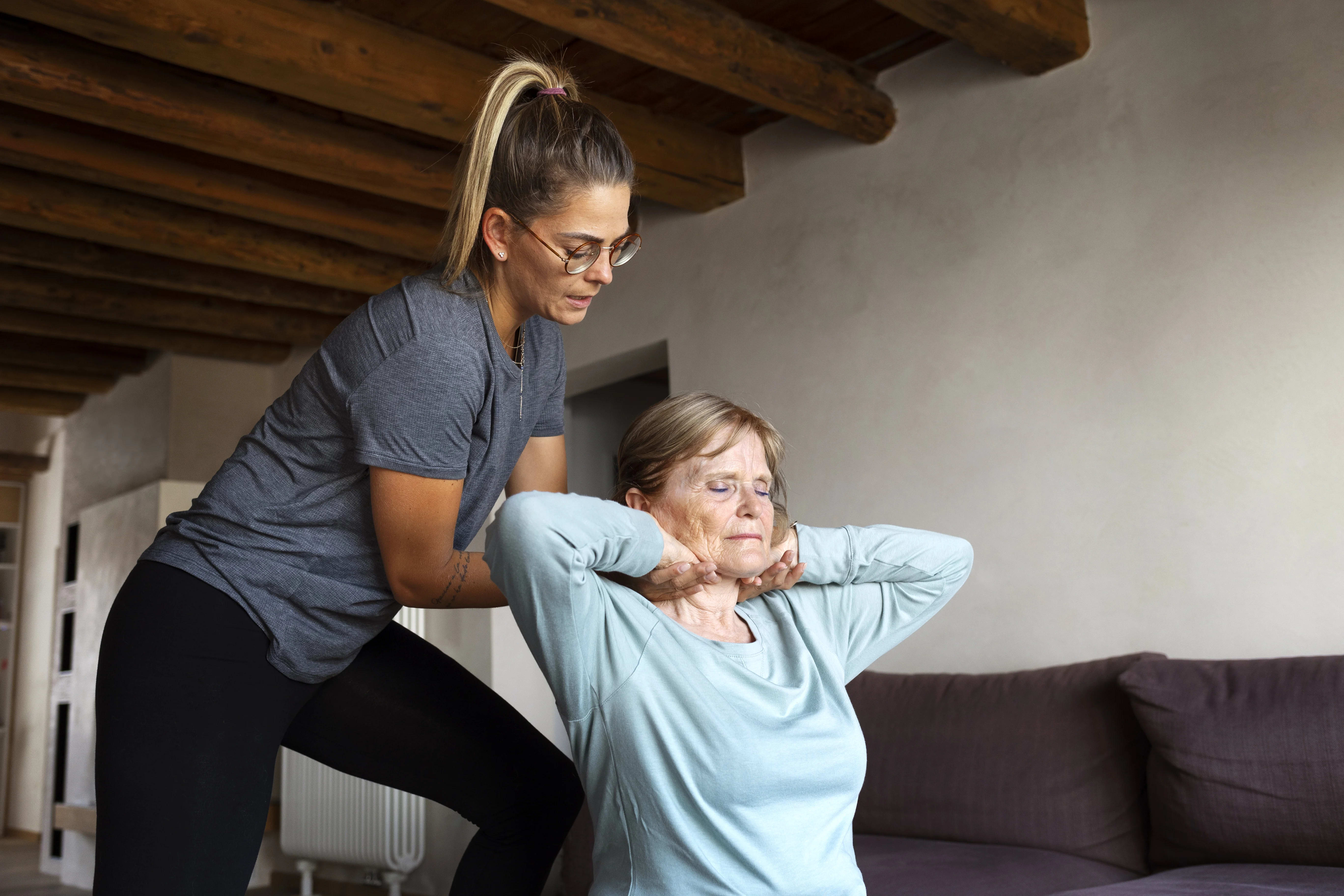 Physical therapist assisting senior patient with neurological rehabilitation
