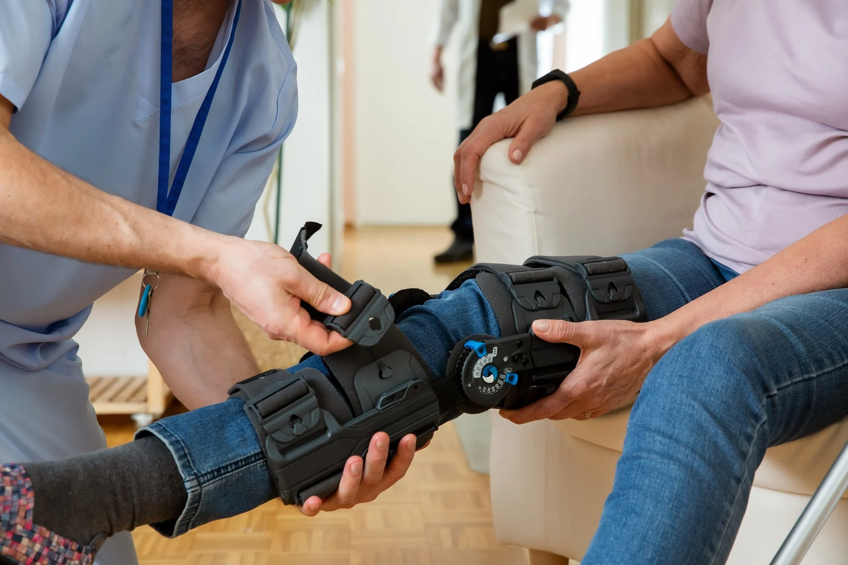 Physical therapist adjusting a knee brace on a patient after ACL surgery to support recovery
