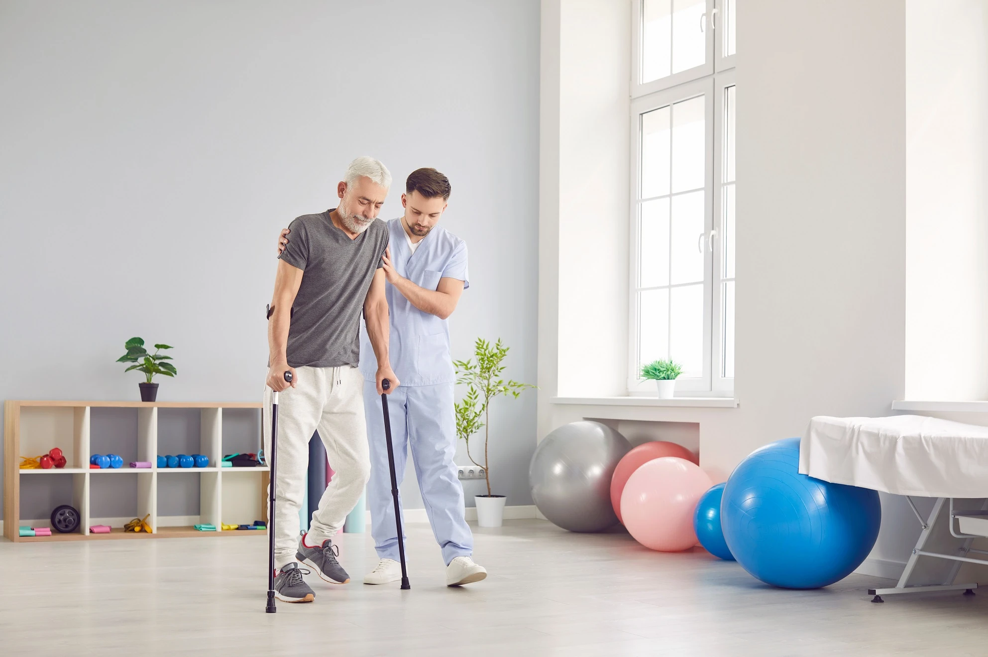 Physical therapist helping a post-surgical patient walk with support