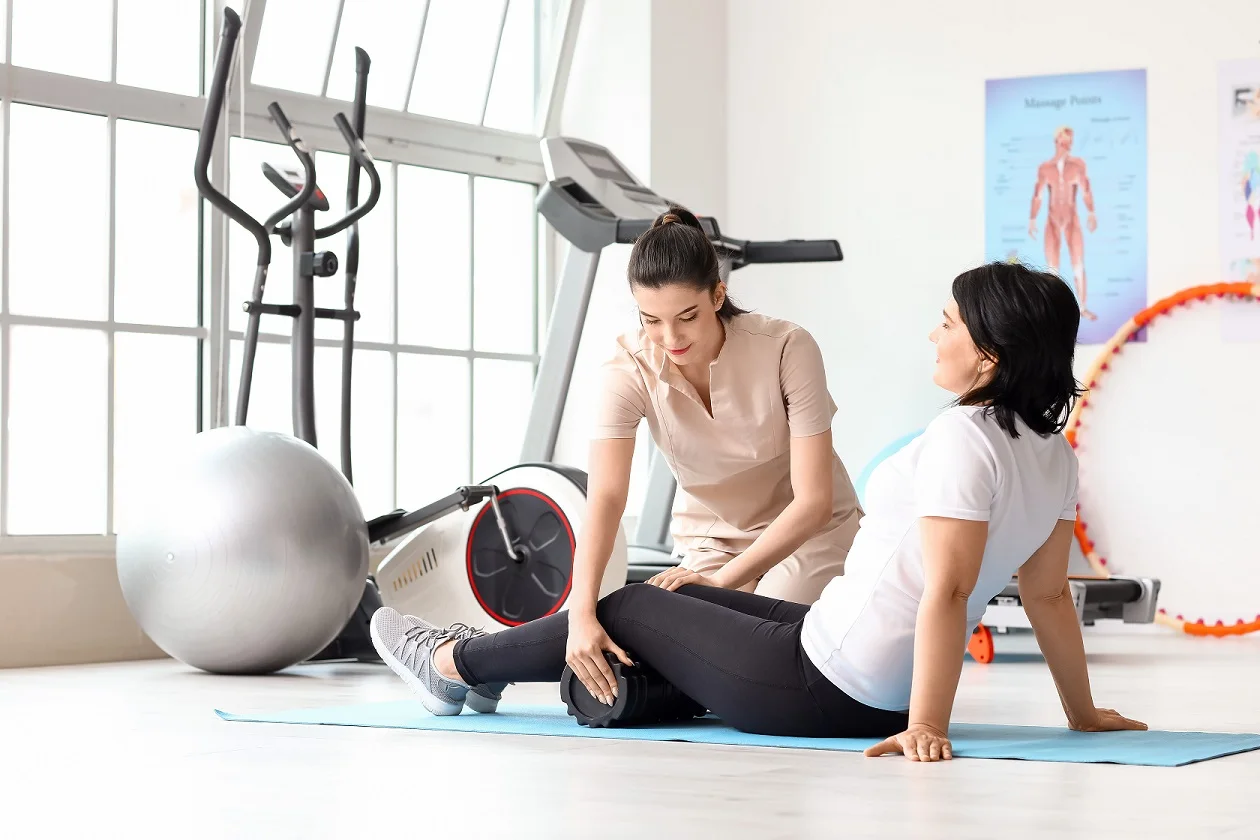 Woman performing core strengthening exercises with a female physical therapist for postpartum pelvic floor rehabilitation