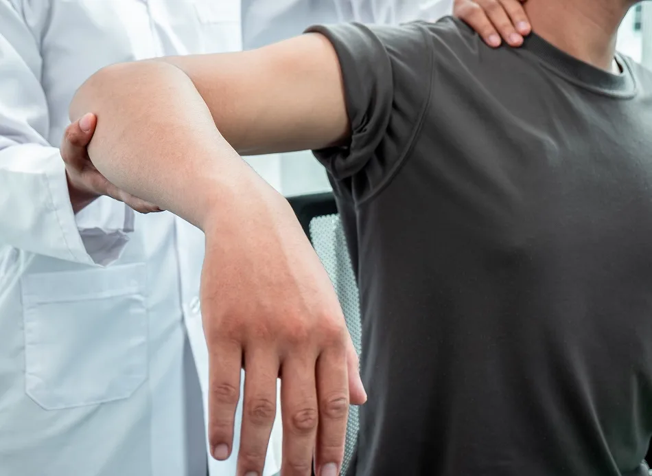 Physical therapist examining a patient's swollen arm during a lymphedema evaluation