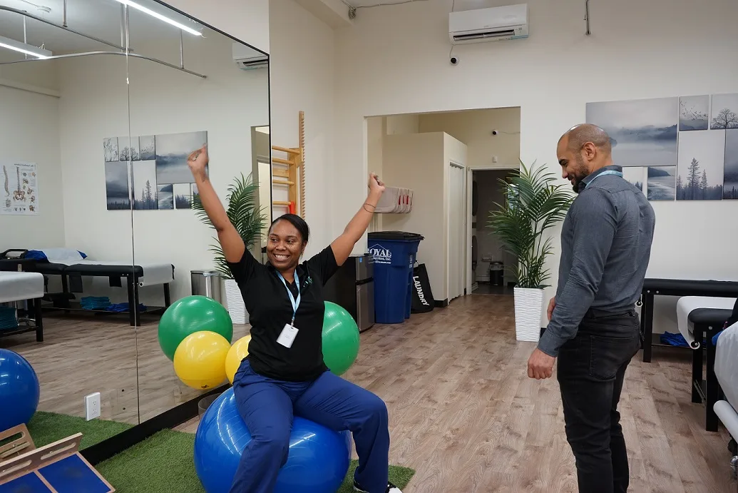Physical therapist guiding a patient through rehabilitation exercises on a stability ball at PT of the City clinic