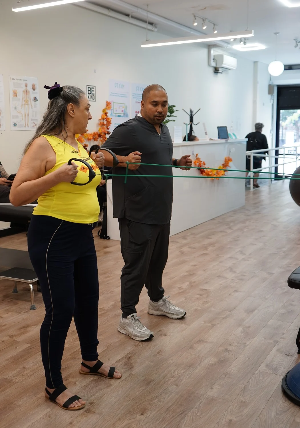 Physical therapist guiding a patient through resistance band rehabilitation exercises at PT of the City clinic
